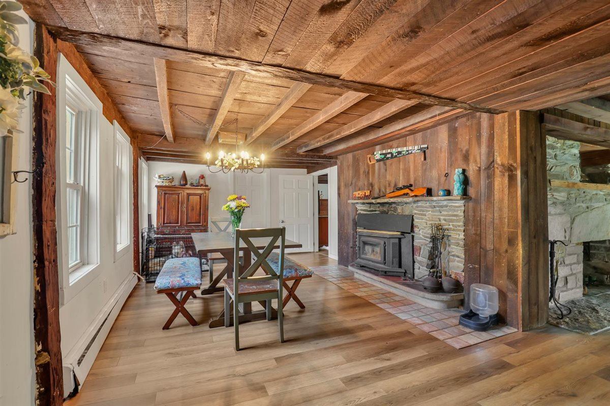 Dining room with center chimney fireplace and exposed beams