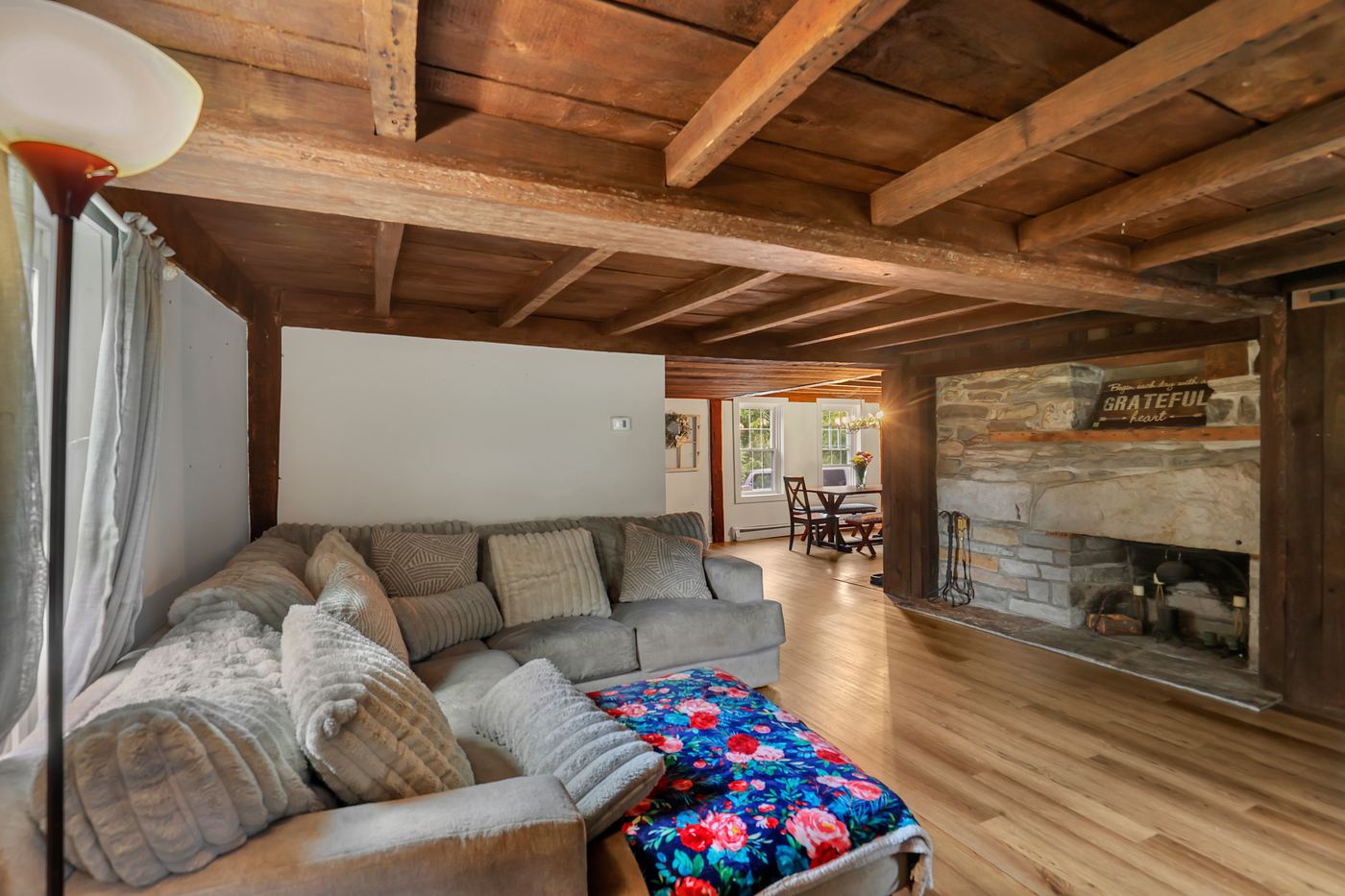 Living room with original stone fireplace and exposed beam ceiling